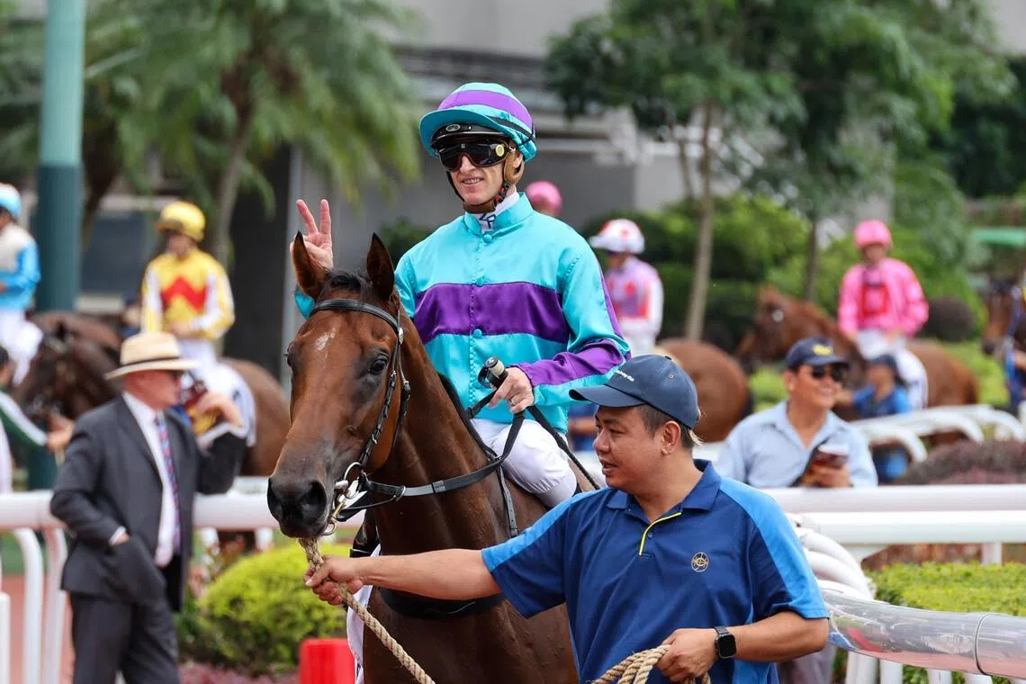 Champion jockey Zac Purton flashing two fingers to celebrate his 2,000th win milestone aboard Rising World at Sha Tin on May 31.