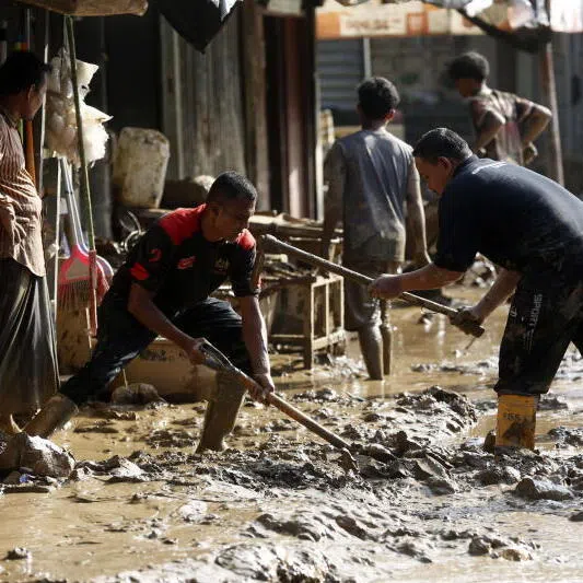 Residents clean up their houses from the mud in a flood-affected village in the Meureudu area, Pidie Jaya Aceh, Indonesia, on Dec 1.
