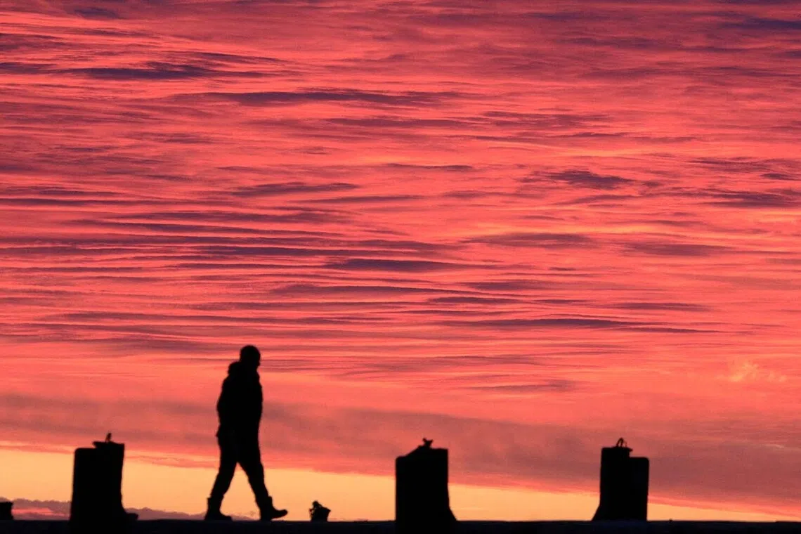 A fisherman walks on a pier over calm waters of the Black Sea at sunset off the coast of Yevpatoriya, Crimea, December 14, 2025. REUTERS/Alexey Pavlishak TPX IMAGES OF THE DAY