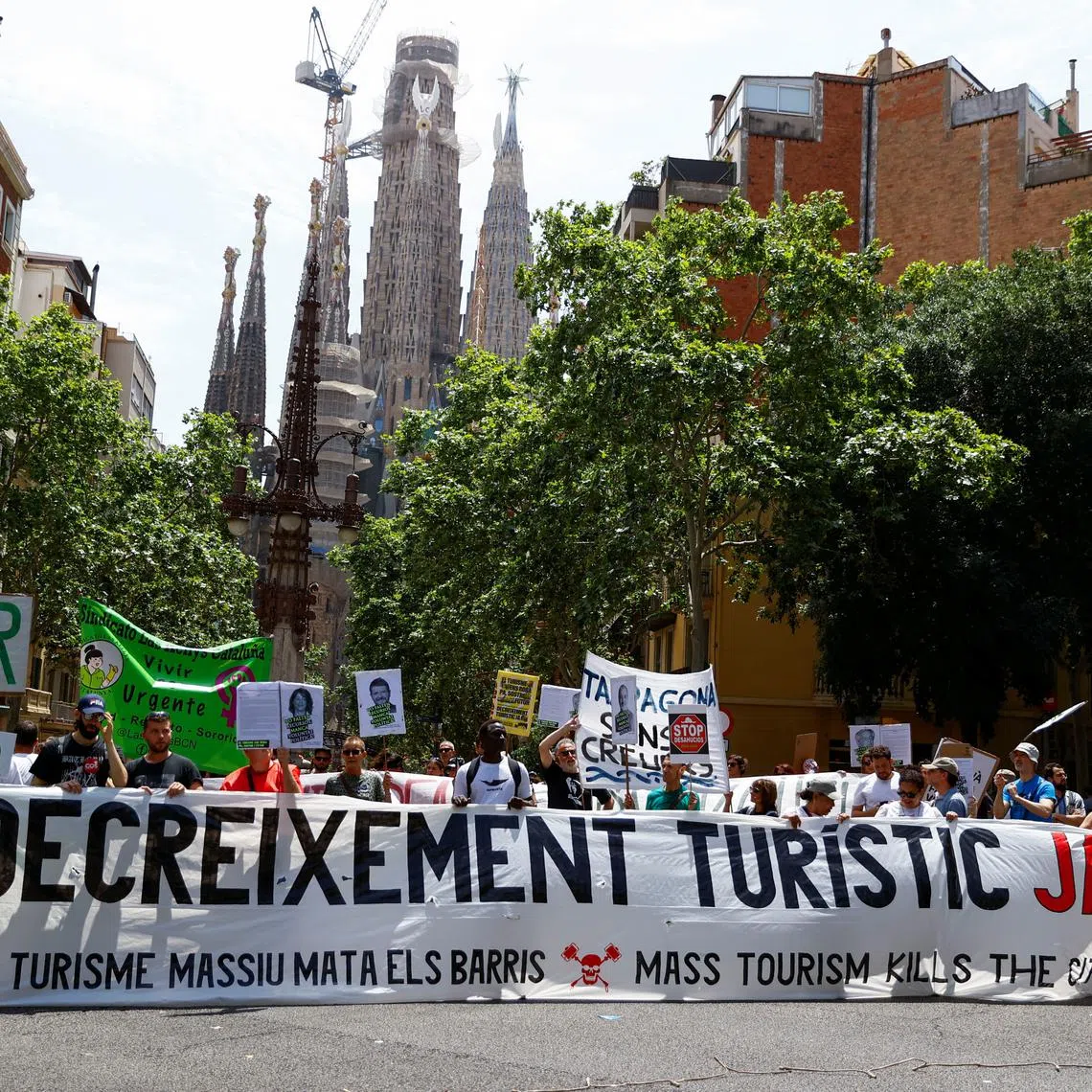 People hold a banner which reads \"Decrease tourism now\" during a protest against mass tourism, in Barcelona, Spain June 15, 2025. REUTERS/Bruna Casas