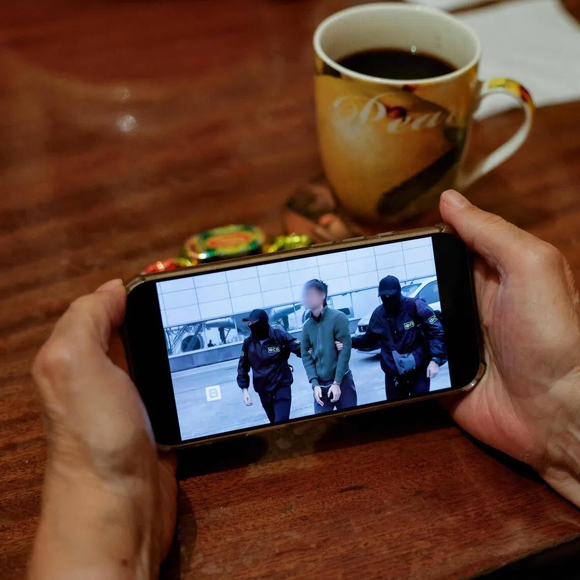A news report is seen on a smartphone running footage of Moscow’s detention of Japanese journalist Yuki Imai on allegations of espionage that Tokyo says is fabricated.