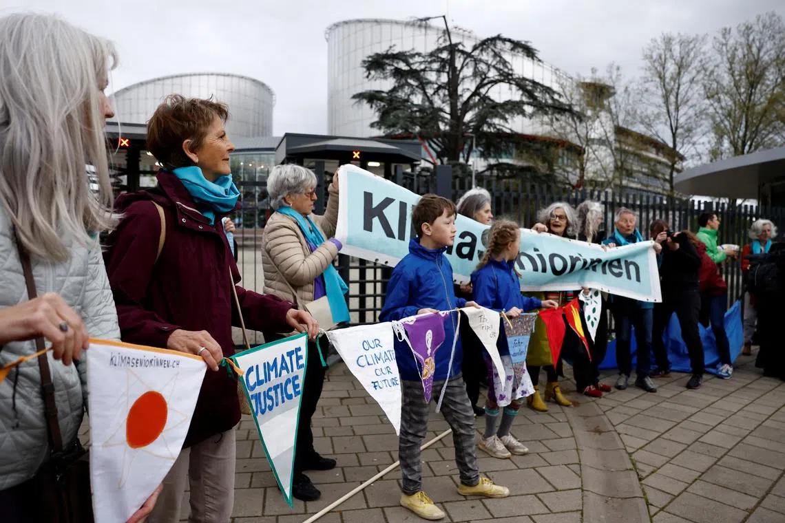 Supporters and members of the association Senior Women for Climate Protection hold banners as they arrive for the ruling in the climate case Verein KlimaSeniorinnen Schweiz and Others v. Switzerland, at the European Court of Human Rights (ECHR) in Strasbourg, France, April 9, 2024. The slogan reads \"Climate justice\". REUTERS/Christian Hartmann
