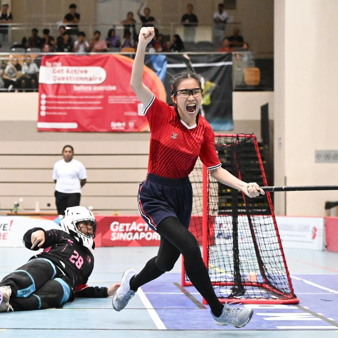 Dahya Nasrul Muhaimin (in red) celebrates after scoring one of her four goals in Marsiling Secondary School's 5-2 win over Swiss Cottage Secondary School in the National School Games floorball B Division girls' final.