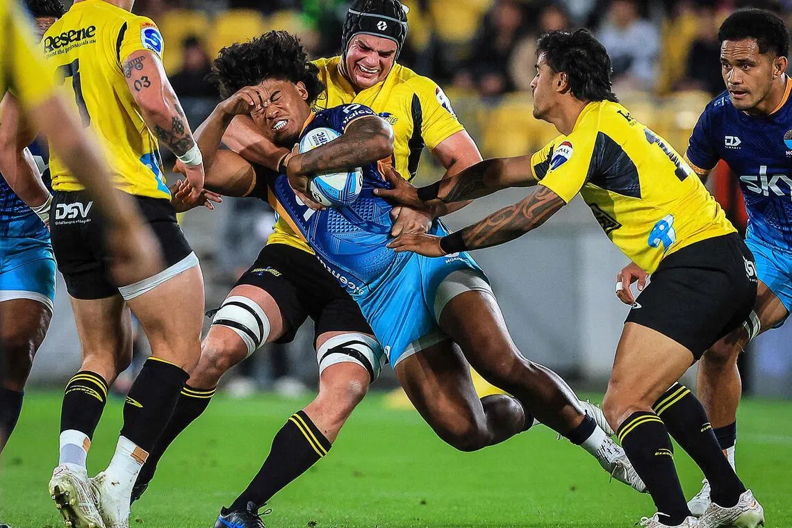 Danny Toala of Moana Pasifika being tackled by Wellington Hurricanes' Justin Sangster in their Super Rugby match at Sky Stadium in Wellington on May 17, 2024.