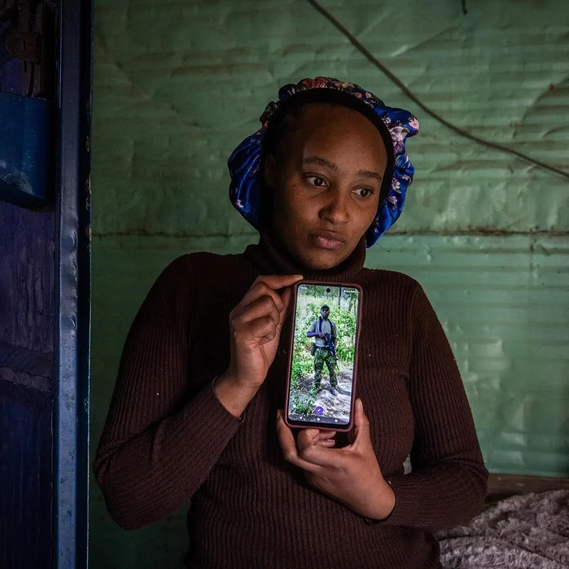 Ms Jane Wanjiku holds up a photo of her husband, James Kamau Ndungu, who died fighting for Russia.