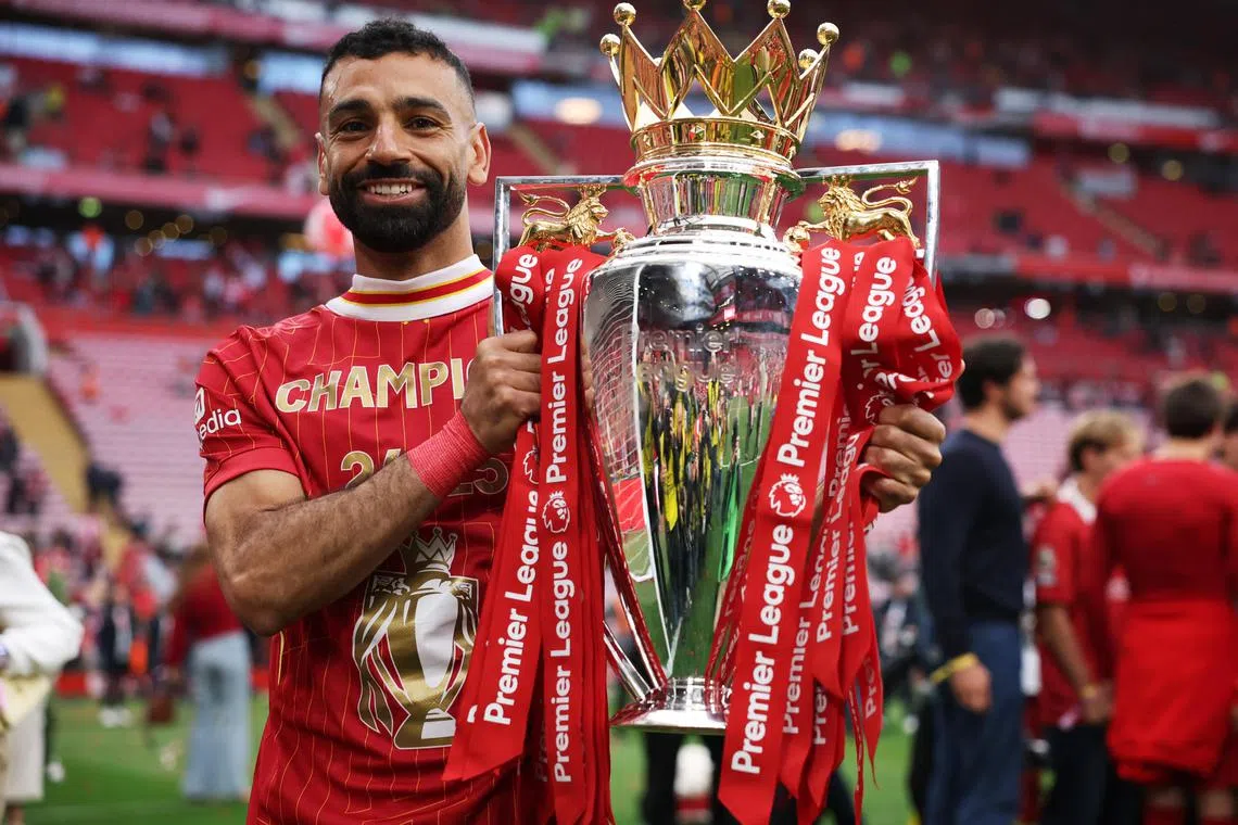 Mohamed Salah celebrates with the trophy after winning the Premier League.