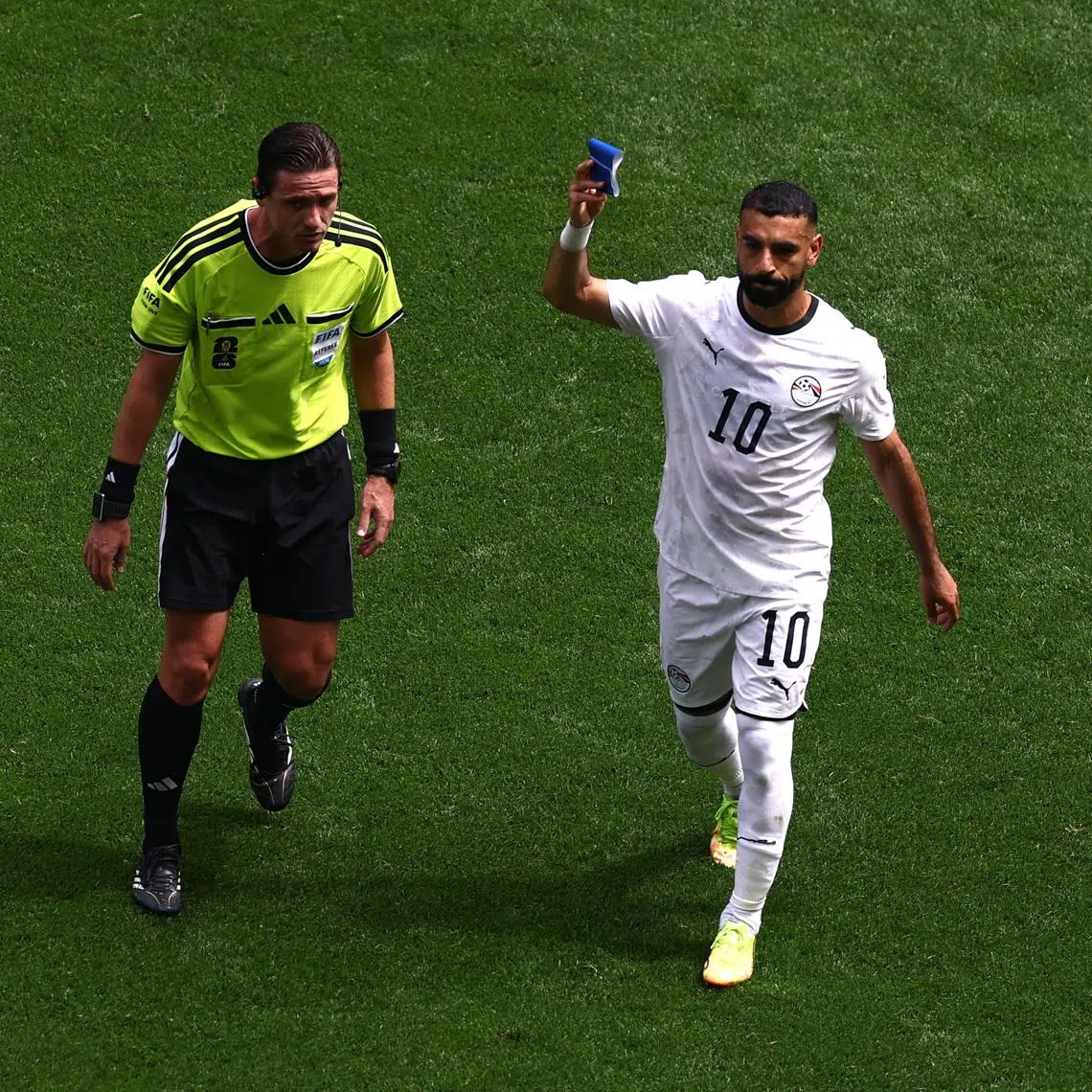 Soccer Football - FIFA World Cup 2026 - Group G - Belgium v Egypt - Seattle Stadium, Seattle, Washington, U.S. - June 15, 2026 Egypt's Mohamed Salah holds up the captains armband as he is substituted as referee Ramon Abatti looks on REUTERS/Lee Smith