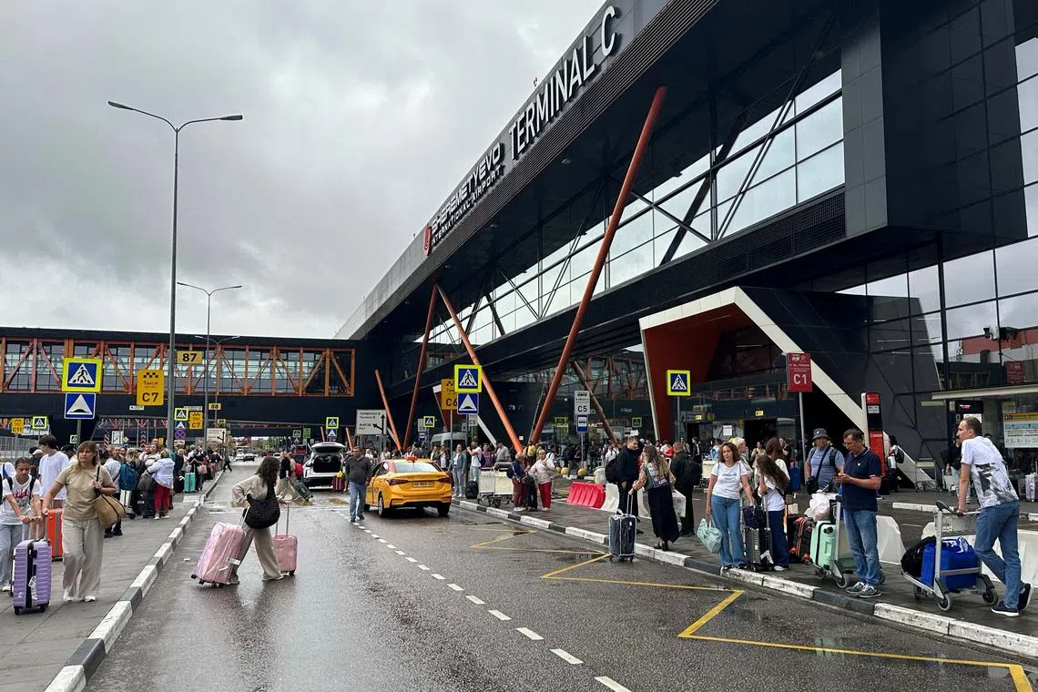 FILE PHOTO: People wait outside Terminal C at the Sheremetyevo international airport outside Moscow, Russia July 21, 2025. REUTERS/Stringer/File Photo