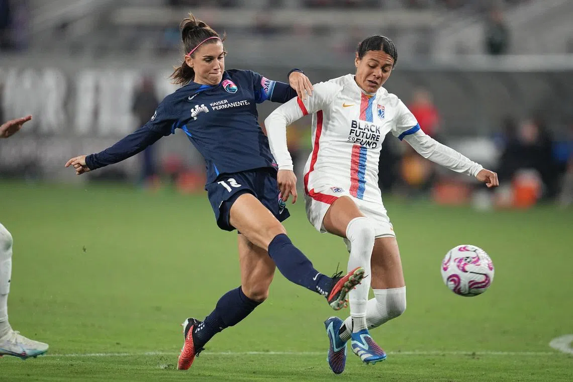 San Diego Wave FC forward Alex Morgan (No. 13) and OL Reign defender Alana Cook battling for the ball in the NWSL semi-finals.