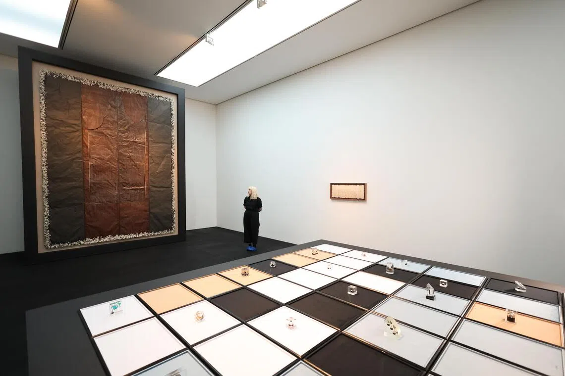 Gallery worker Sophie Ascough poses with British artist Tanoa Sasraku’s presentation during a press preview.