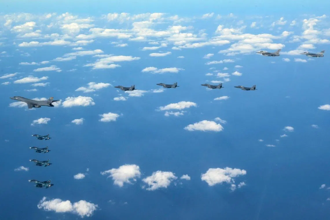 A US Air Force B-1B bomber escorted by fighter jets fly over the South Korean island of Jeju during a joint air drill.
