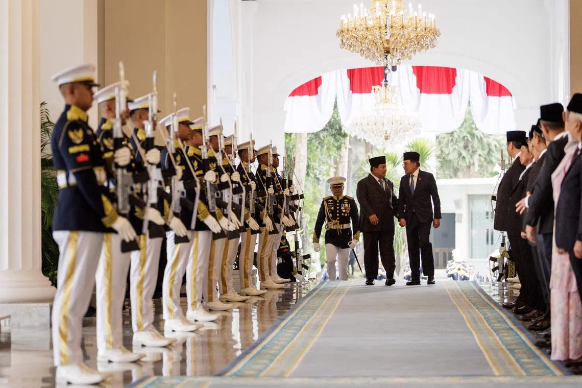 Malaysia's Prime Minister Anwar Ibrahim (right) and Indonesias President Prabowo Subianto walk together ahead of their bilateral meeting at the Presidential Palace in Jakarta, on July 29.