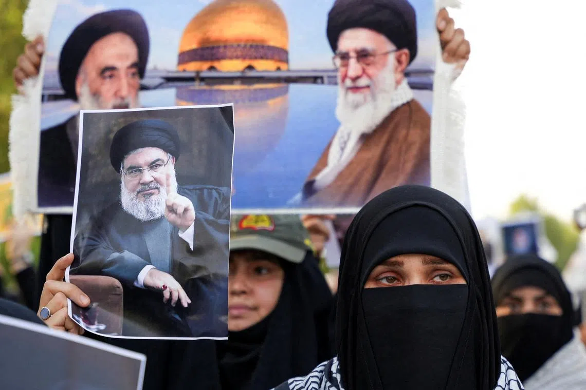 A woman holds a picture of Lebanon's Hezbollah Chief Hassan Nasrallah who was killed by an Israeli airstrike in Beirut, during a symbolic funeral in Basra, Iraq, September 29, 2024. REUTERS/Essam al-Sudani