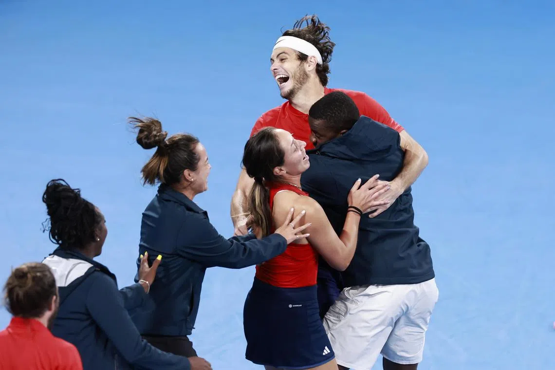 Taylor Fritz of the United States is hugged by teammates after winning against Italian Matteo Berrettini to clinch the United Cup in Sydney. 