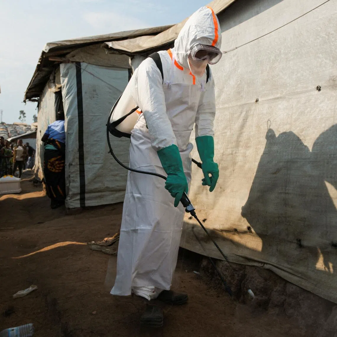 A health worker in full personal protective equipment (PPE) disinfects an area while preparing for the burial of suspected Ebola victims at the Kigonze displaced persons camp in Bunia, eastern Democratic Republic of Congo, on June 18, 2026, one month after the outbreak was declared. REUTERS/Gradel Muyisa Mumbere