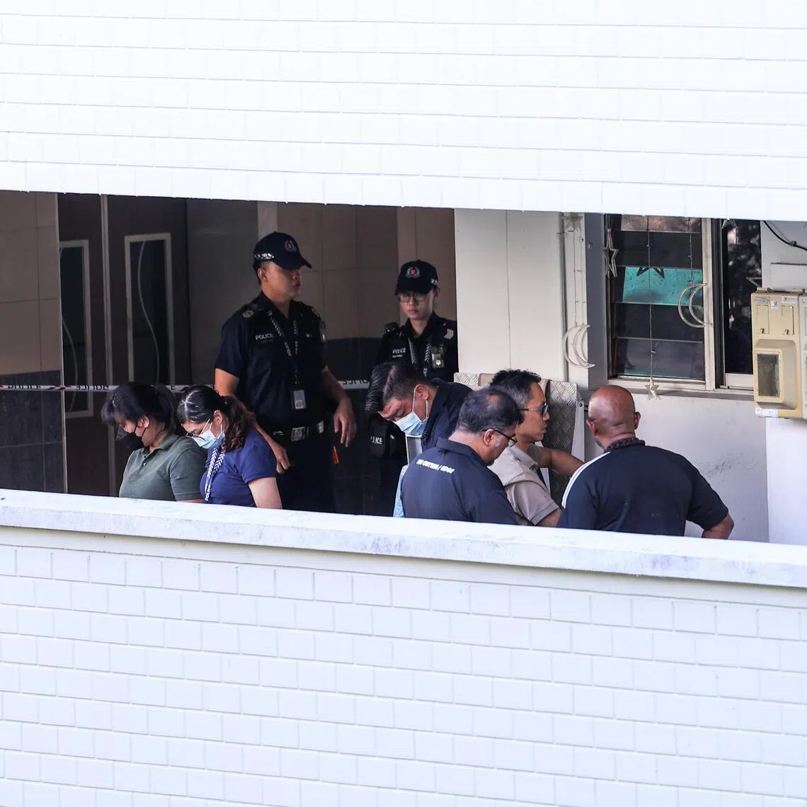 Police officers inspecting the murder scene at a Bukit Panjang flat in 2024.