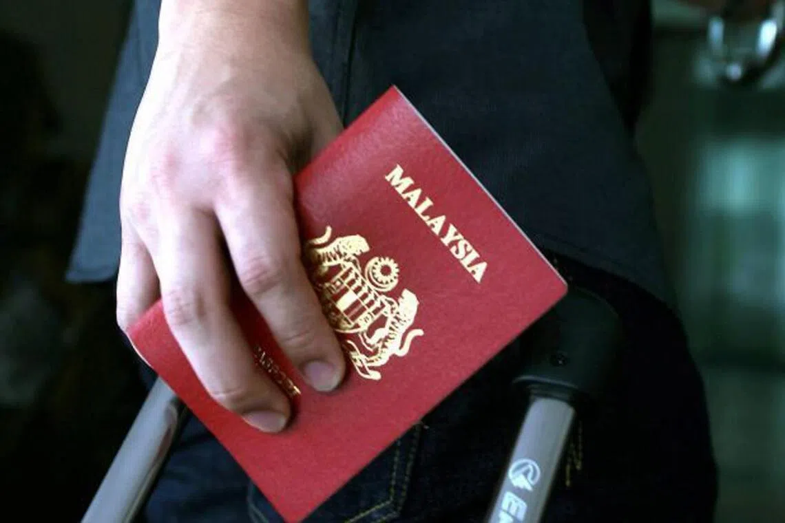 A person holding a Malaysian passport.