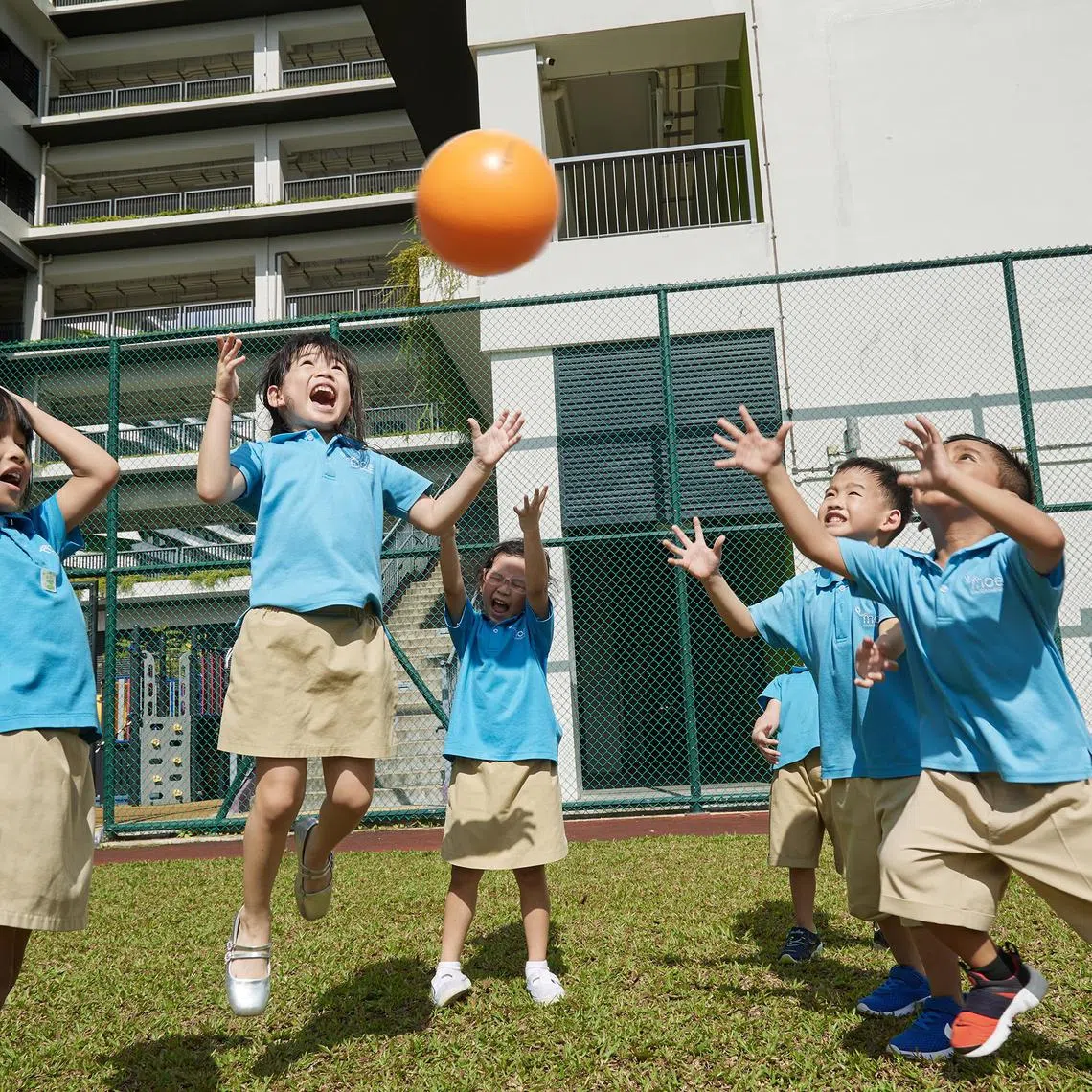Children from MOE Kindergarten@Valour work together to keep a ball in the air in a collaborative game at the field shared with its primary school. 
