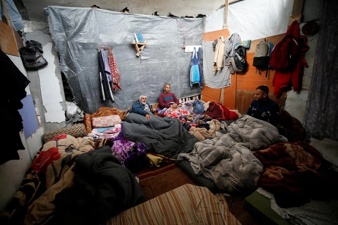 Palestinians take shelter at their ruined house, on a rainy day, amid a ceasefire between Israel and Hamas, in Jabalia refugee camp in the northern Gaza Strip February 11, 2025. REUTERS/Mahmoud Issa
