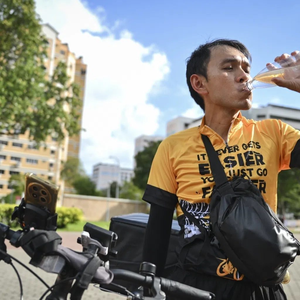 Delivery rider says frequent water breaks help him cope with the heat