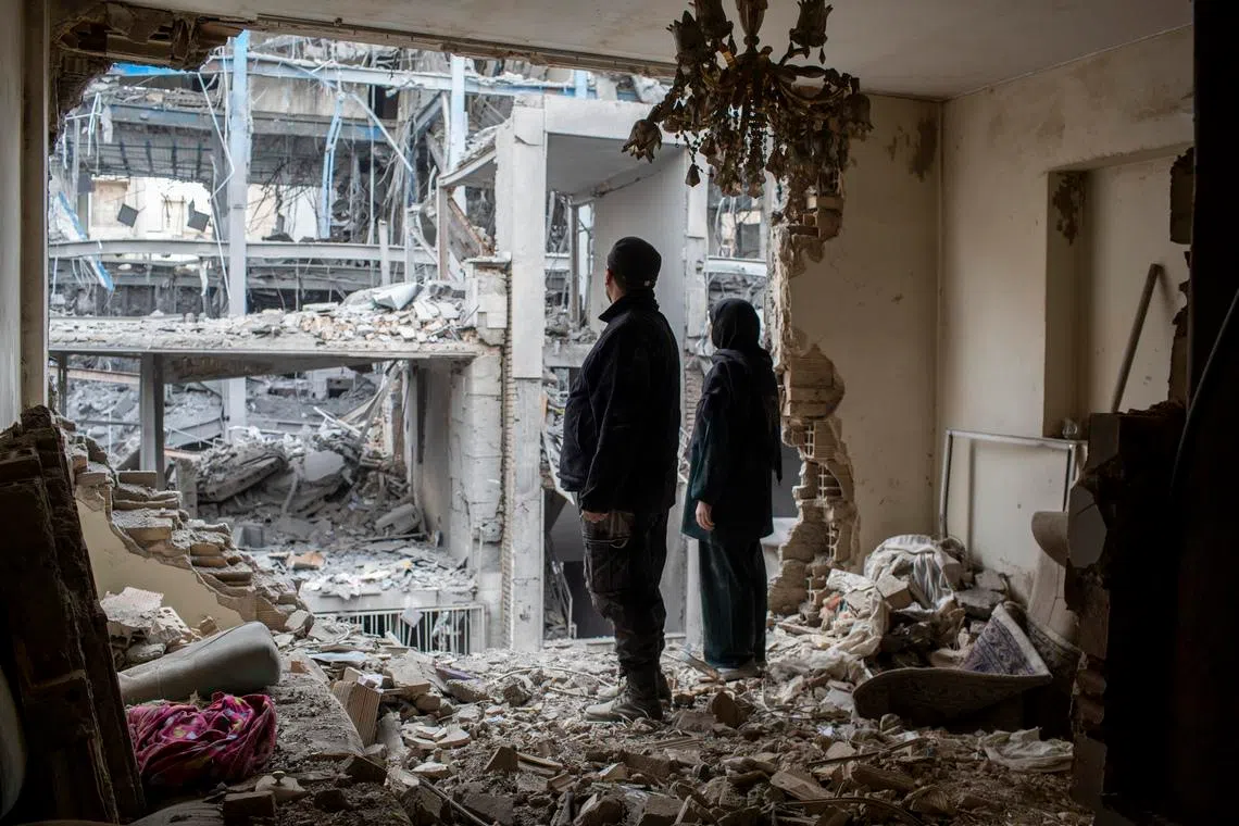 A couple stands in the ruins of their apartment after an air strike in Tehran, Iran, on March 15.