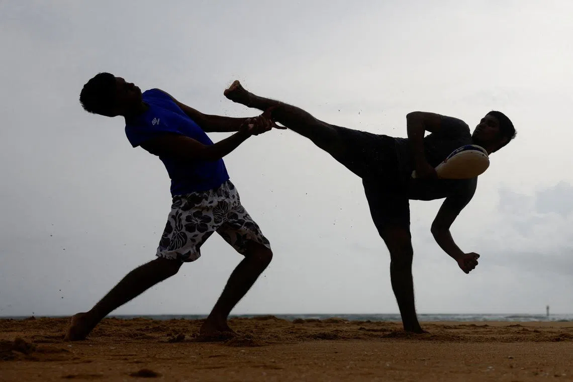Two men performing martial arts on a beach in a suburb town of Colombo, Sri Lanka July 2.