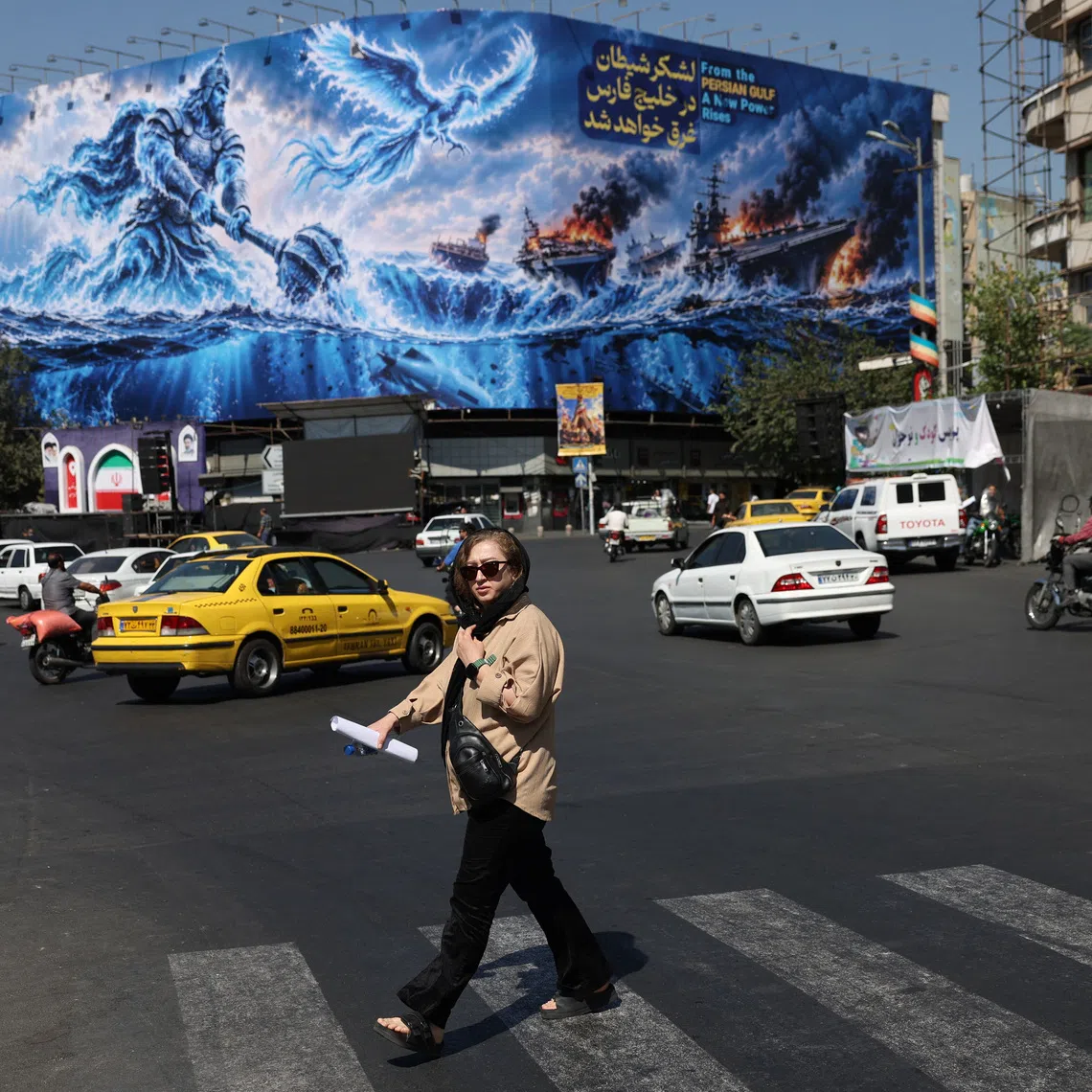 A woman walks past a billboard about the Strait of Hormuz, on a building in Tehran, Iran, September 16, 2026. Majid Asgaripour/WANA (West Asia News Agency) via REUTERS