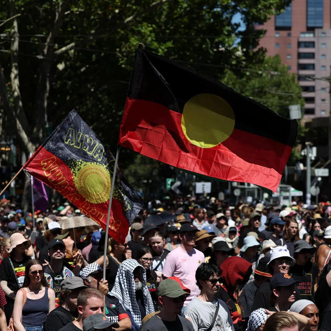 A man holds an Australian Aboriginal flag as protestors gather for an "Invasion Day" rally on Australia's national day in Melbourne, Australia.