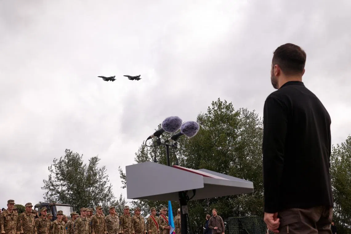 Ukrainian President Volodymyr Zelensky watching an F-16 flypast at a military event in Ukraine in August 2024.