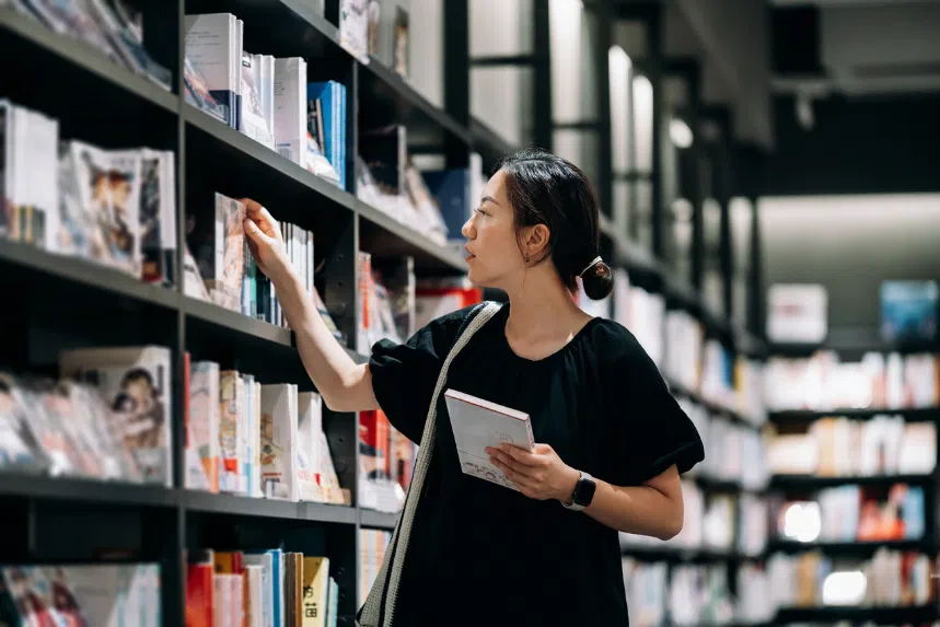 Where to buy SingLit books in Singapore: Chinese woman selecting books from shelf