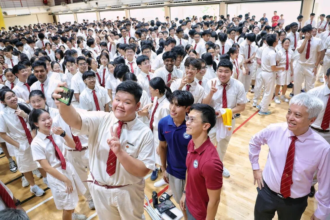 Lions head coach Gavin Lee (maroon top) and winger Glenn Kweh (dark blue top) taking a wefie with student Clarence Kuan during an engagement session at Victoria Junior College on Feb 23, 2026.