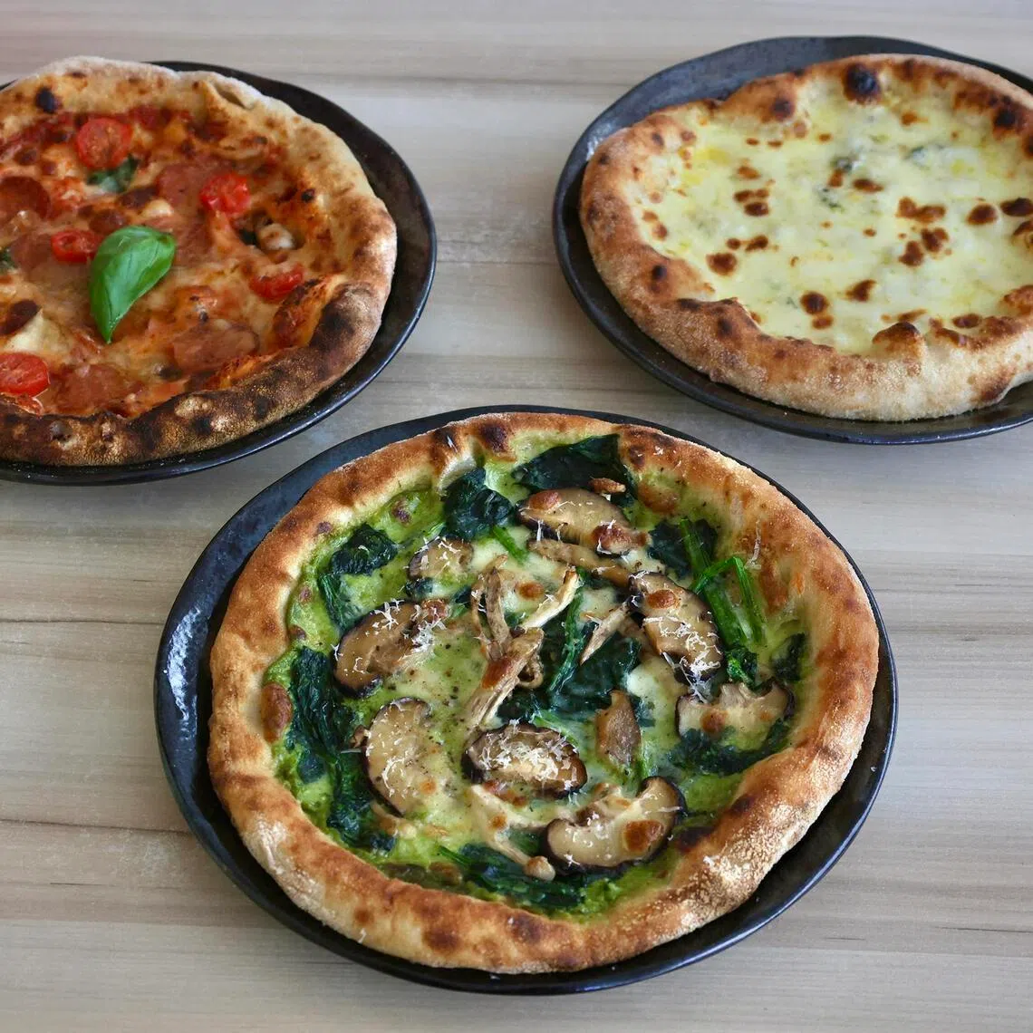 From left (clockwise): Pepperoni Pizza, Four Cheese Pizzw and Pesto With Spinach And Mushroom at Bami Express.