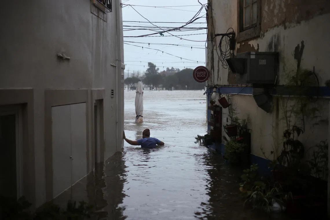 A man enters floodwater to reach his house as storm Leo flooded the streets of Alcacer do Sal, Portugal, February 4, 2026. REUTERS/Pedro Nunes