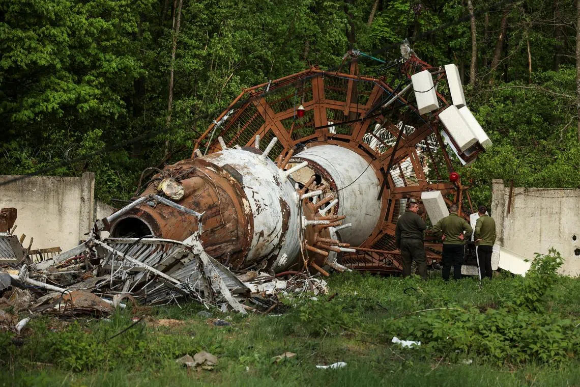 People stand next to a part of a television tower partially destroyed by a Russian missile strike, amid Russia's attack on Ukraine, in Kharkiv, Ukraine April 22, 2024. REUTERS/Sofiia Gatilova