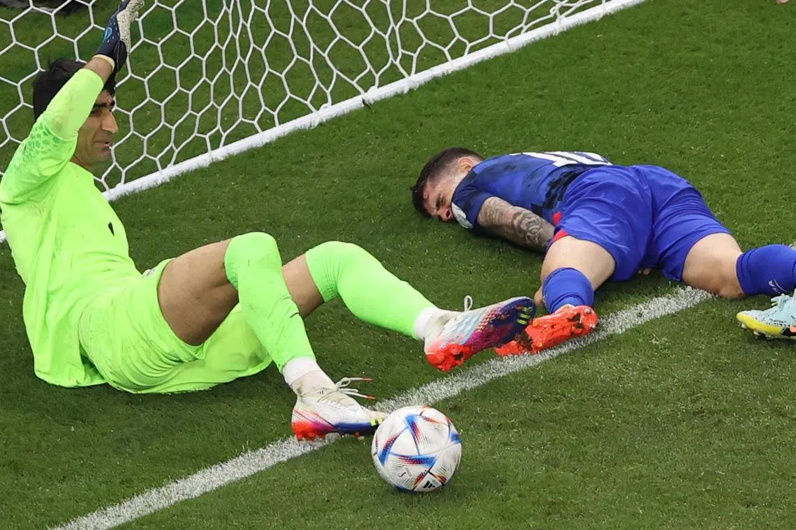 Christian Pulisic (right) suffered an abdominal injury after crashing to  Iranian goalkeeper Alireza Beiranvand while scoring for the US.