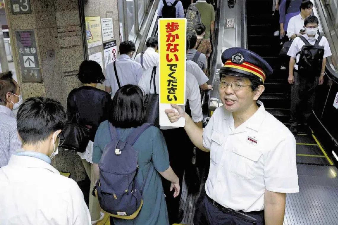 A Nagoya municipal subway employee urges commuters to stay safe at Hisaya-Odori station.