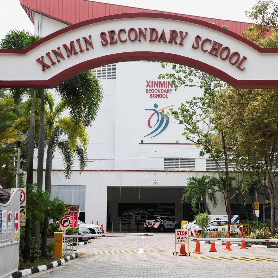 Police vehicles parked at Xinmin Secondary School following a bomb threat on Aug 13.