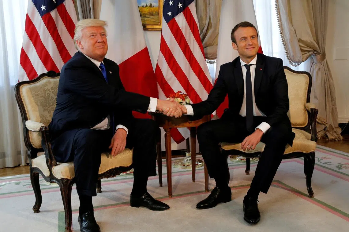 FILE PHOTO: U.S. President Donald Trump (L) and French President Emmanuel Macron shake hands before a lunch ahead of a NATO Summit in Brussels, Belgium, May 25, 2017.  REUTERS/REUTERS/Jonathan Ernst/File Photo