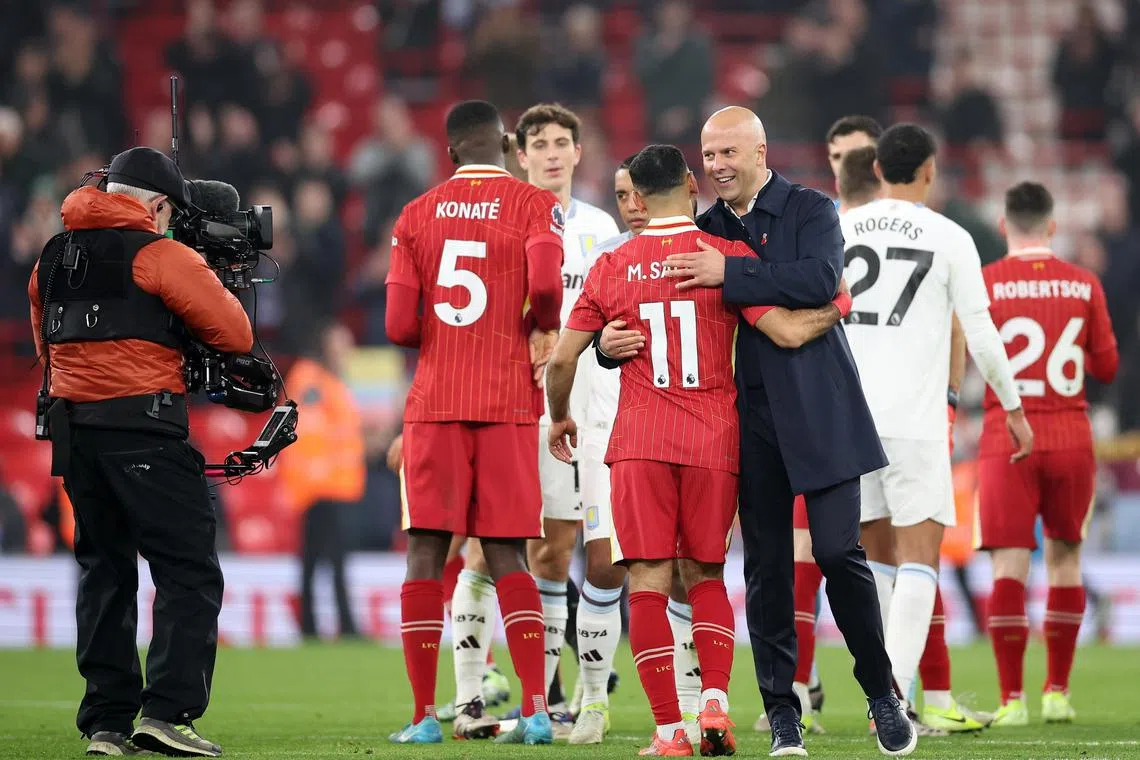 Liverpool manager Arne Slot celebrating with his players after a Premier League match against Aston Villa.