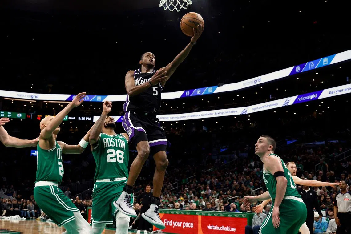 De'Aaron Fox of the Sacramento Kings going to the basket past Xavier Tillman of the Boston Celtics during the second half at TD Garden on April 5.