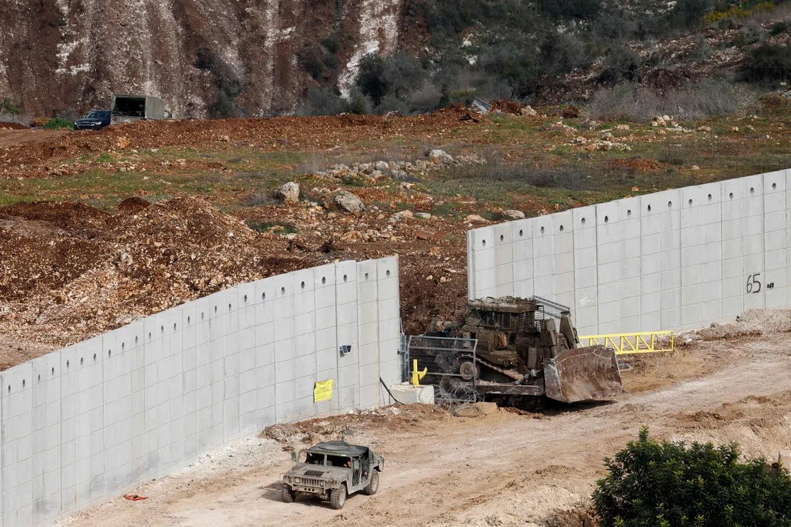 Israeli military vehicles crossing a cement barrier on the border between Israel and the southern Lebanese village of Dhayra on Feb 17.