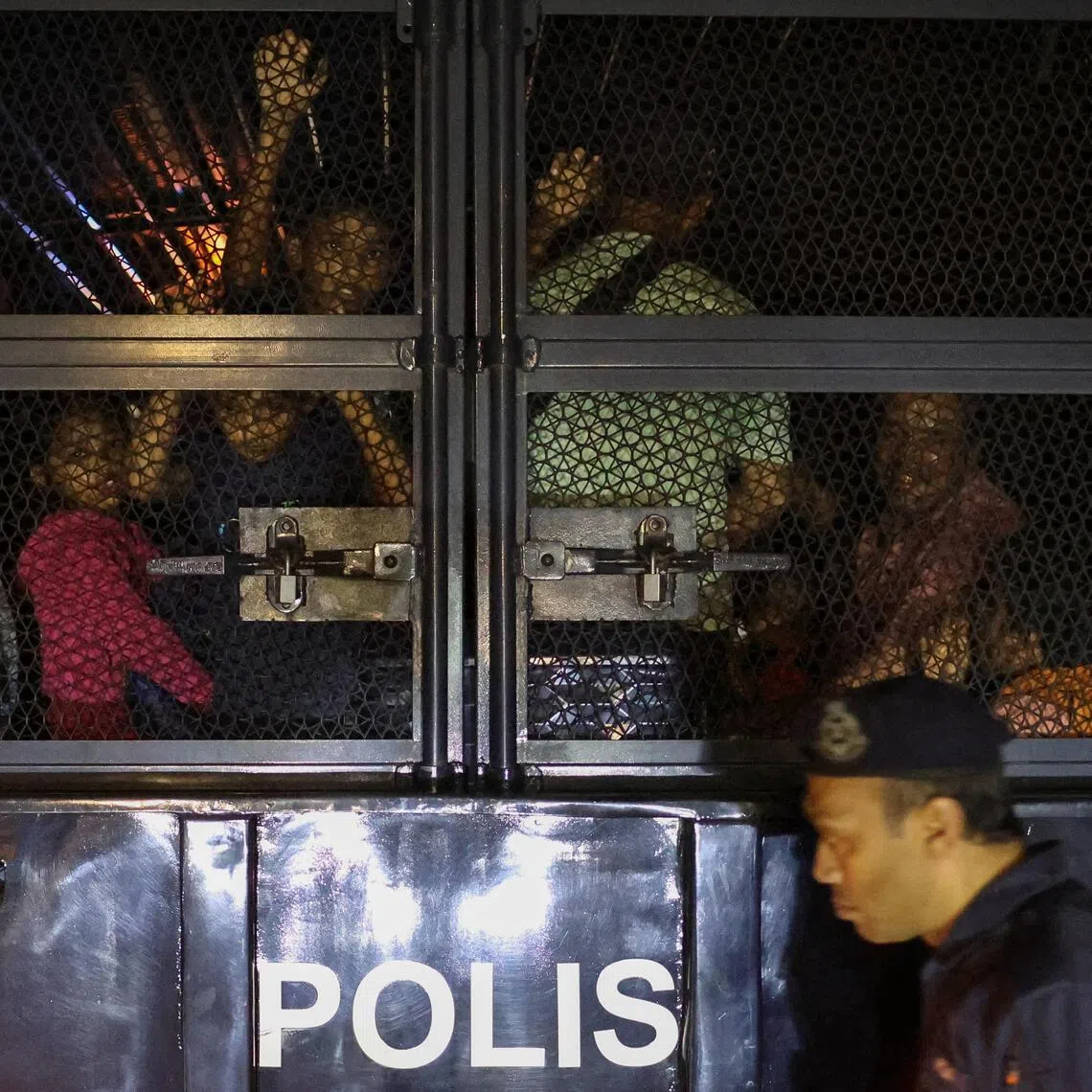 Rohingya refugees taken away by police, in front of the office of the UN refugee agency in Kuala Lumpur, on July 27. They were released after officials confirmed they held valid UN documentation.