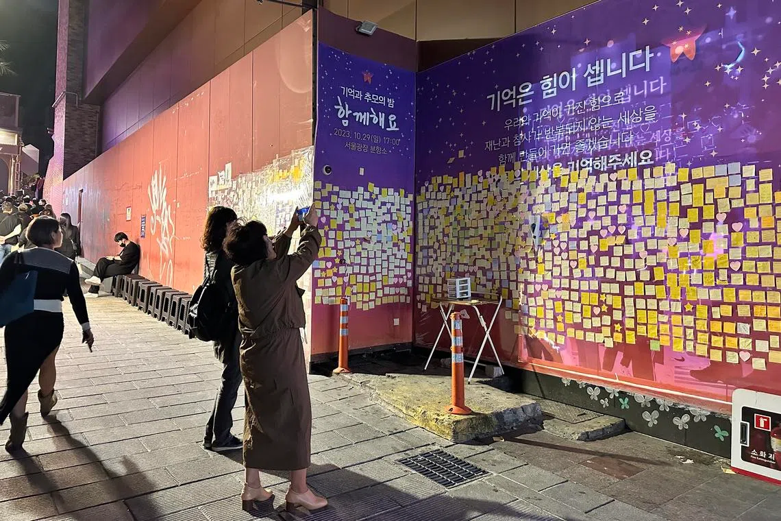 People taking photos of a memorial in October 2023 to remember Halloween revellers killed in 2022 in Seoul’s Itaewon district.