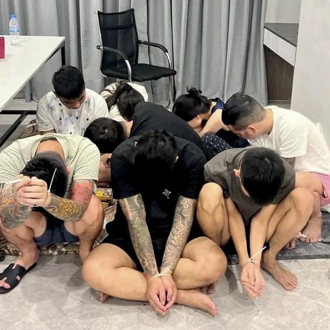 epa12241013 Suspects are seen with their hands zip-tied after being detained during a police raid on a scam center in Phnom Penh, Cambodia, 16 July 2025. The operation was part of a nationwide crackdown on cybercrime networks, following Prime Minister Hun Manet’s order to shut down online scam operations often run like sweatshops.  EPA/TRA / AKP / POOL