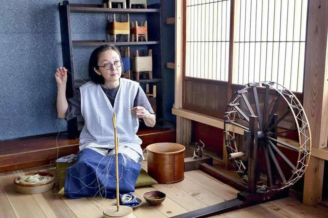 Eriko Yamauchi makes thread in a quiet environment where bird songs can be heard, in Showa, Fukushima Prefecture.