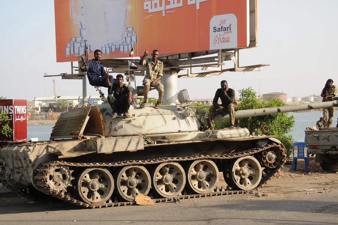 Sudanese army soldiers, loyal to army chief Abdel Fattah al-Burhan, sit atop a tank in the Red Sea city of Port Sudan, on April 20, 2023.