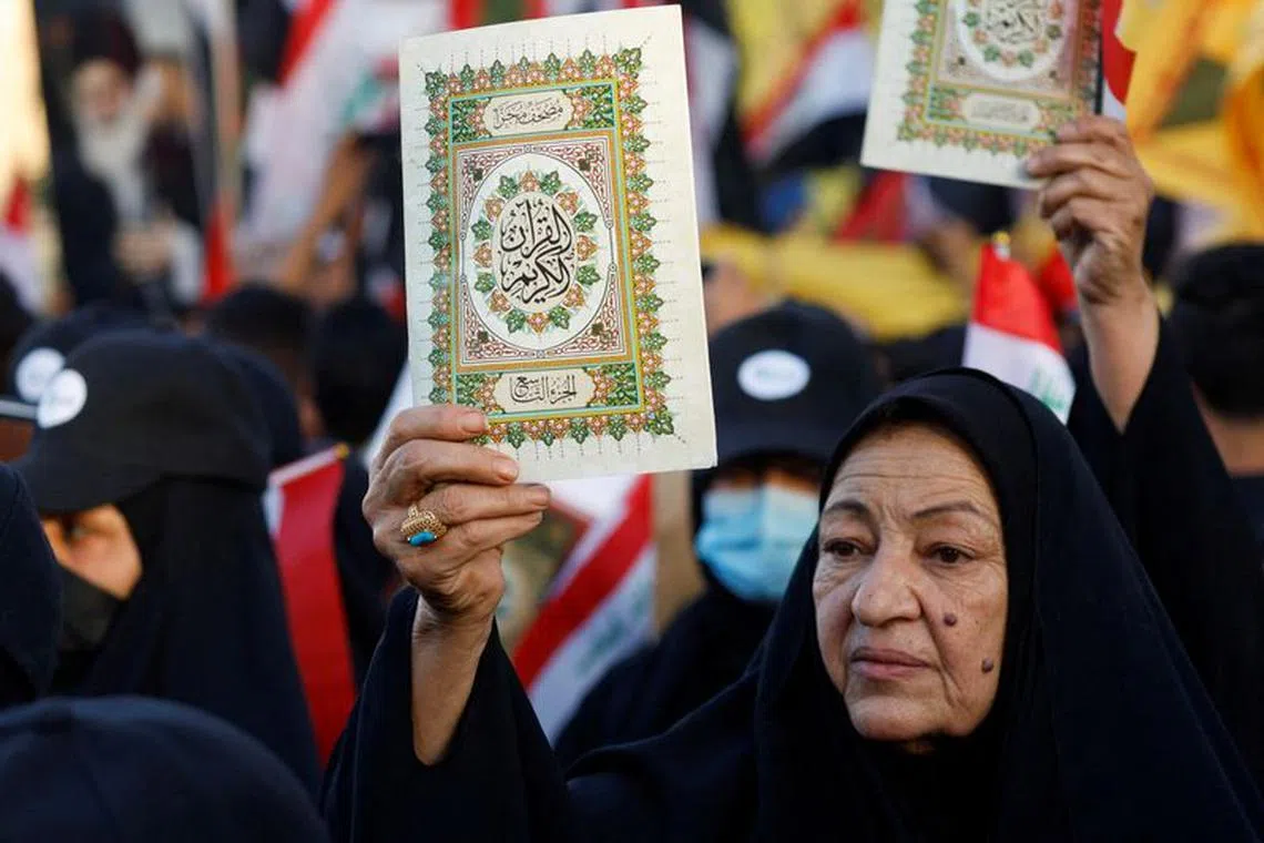 FILE PHOTO: An Iraqi demonstrator holds the Koran during a protest near the Green Zone against the burning of a copy of the Koran and the Iraqi flag in the Swedish capital Stockholm, in Baghdad, Iraq July 22, 2023. REUTERS/Khalid Al-Mousily/File Photo