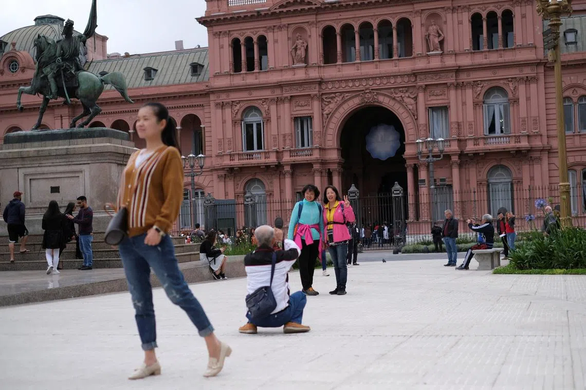 FILE PHOTO: Tourist pose for pictures in front of the presidential palace Casa Rosada in Buenos Aires, Argentina October 29, 2019. REUTERS/Carlos Garcia Rawlins/File Photo