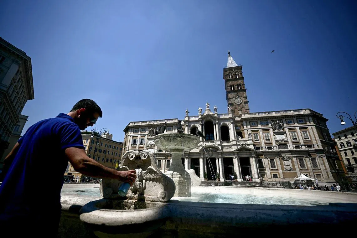 A man fills up a bottle with water at a fountain infront of Santa Maria Maggiore Basilica, in central Rome on August 11, 2025. Italy is facing extreme heat until mid-August as temperatures above 40 degrees centigrade is gripping the entire country at least until the August 15th bank holiday weekend. (Photo by Filippo MONTEFORTE / AFP)