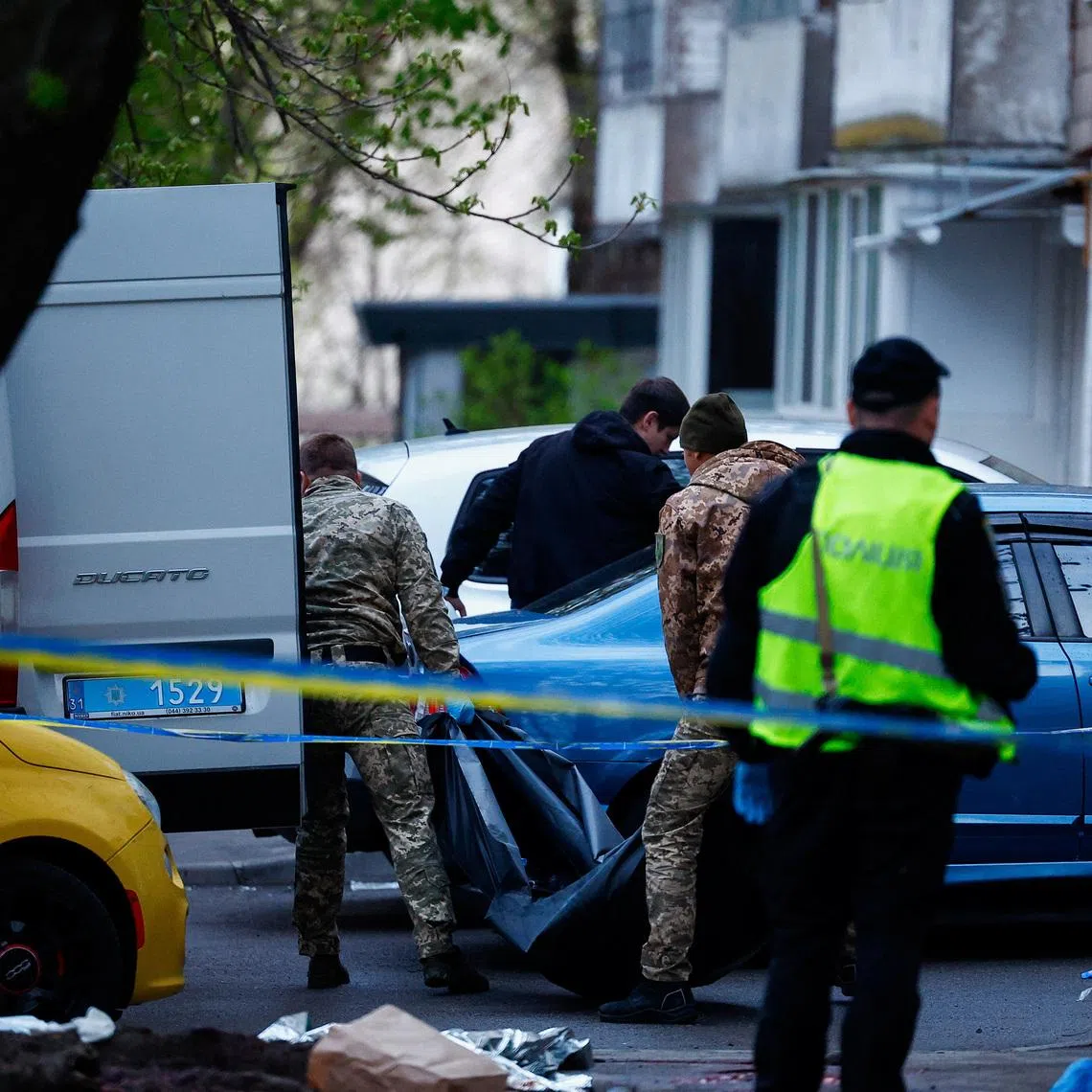 A victim in a bodybag is carried, at the site of a shooting incident, in Kyiv, Ukraine, April 18, 2026.